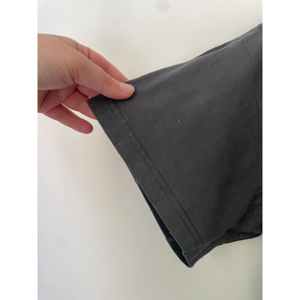 Close-up of a grey t-shirt sleeve held by a hand.