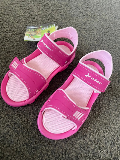 A pair of new pink Rider brand sandals with hook-and-loop straps.