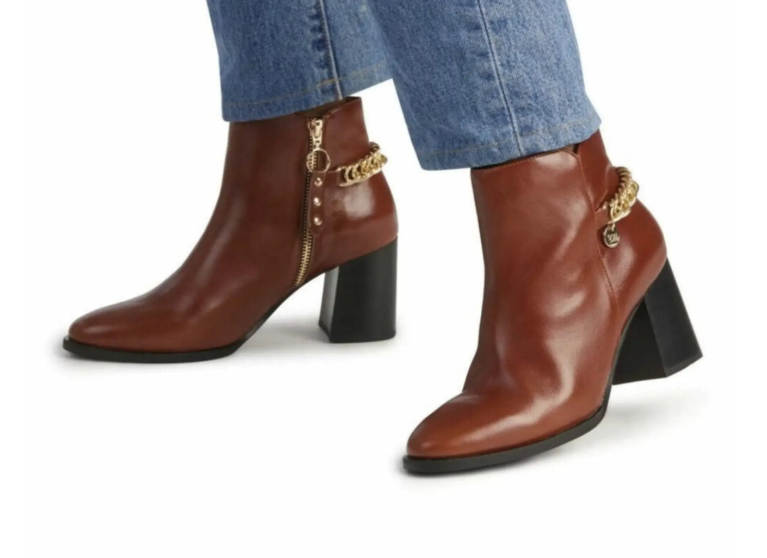 Brown leather ankle boots with gold chain detailing.