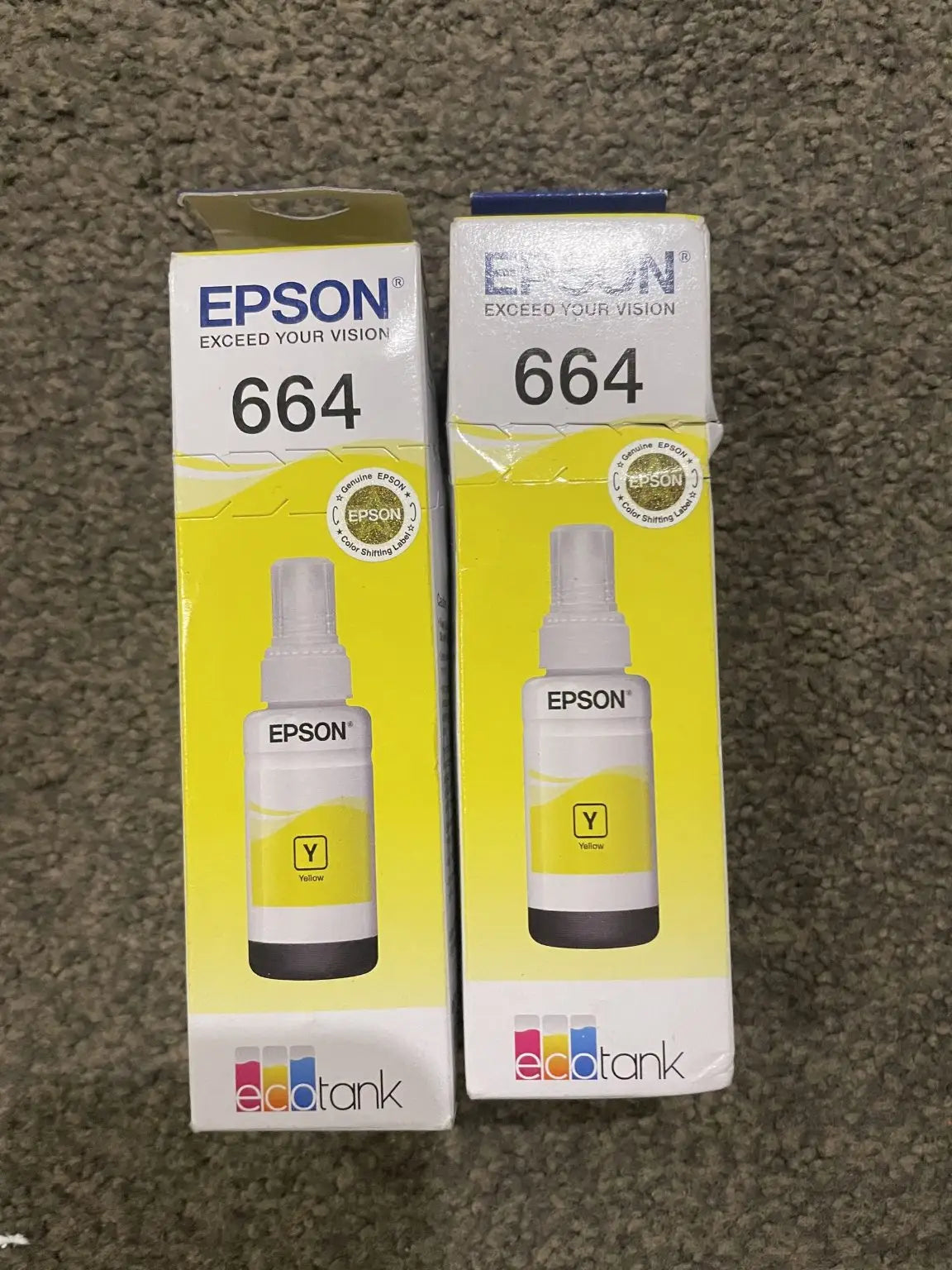 Two yellow Epson 664 EcoTank ink bottles in their original packaging.
