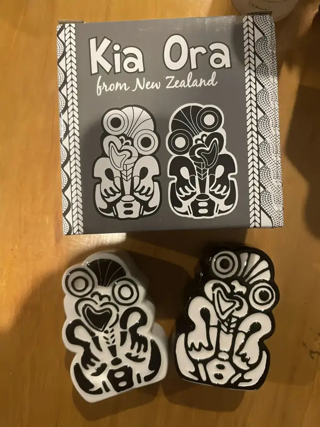 A boxed set of two black and white salt and pepper shakers in the shape of traditional Maori carvings.