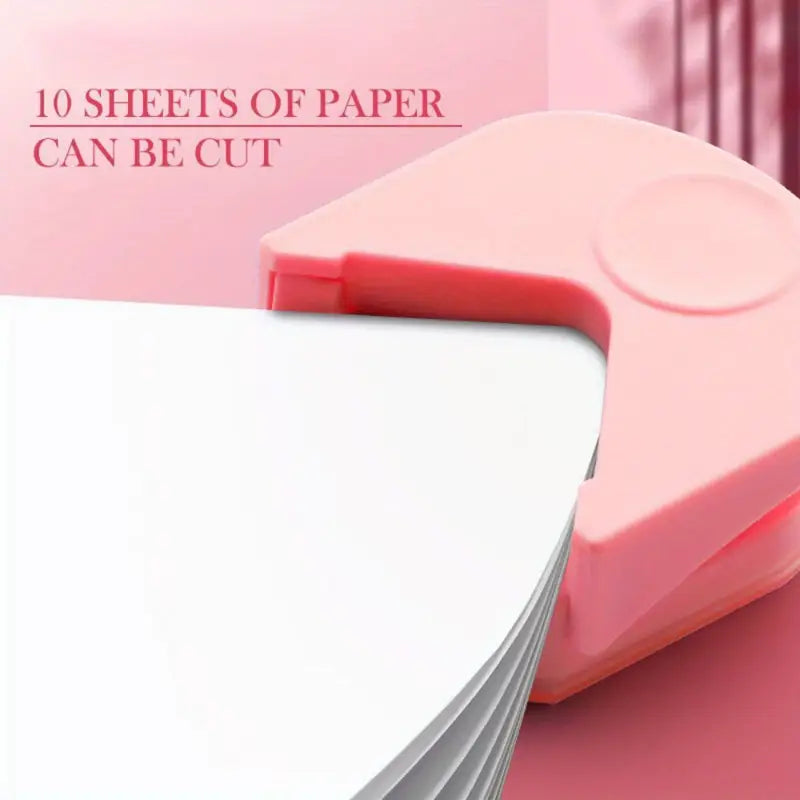 A pink corner rounder punching a stack of paper.