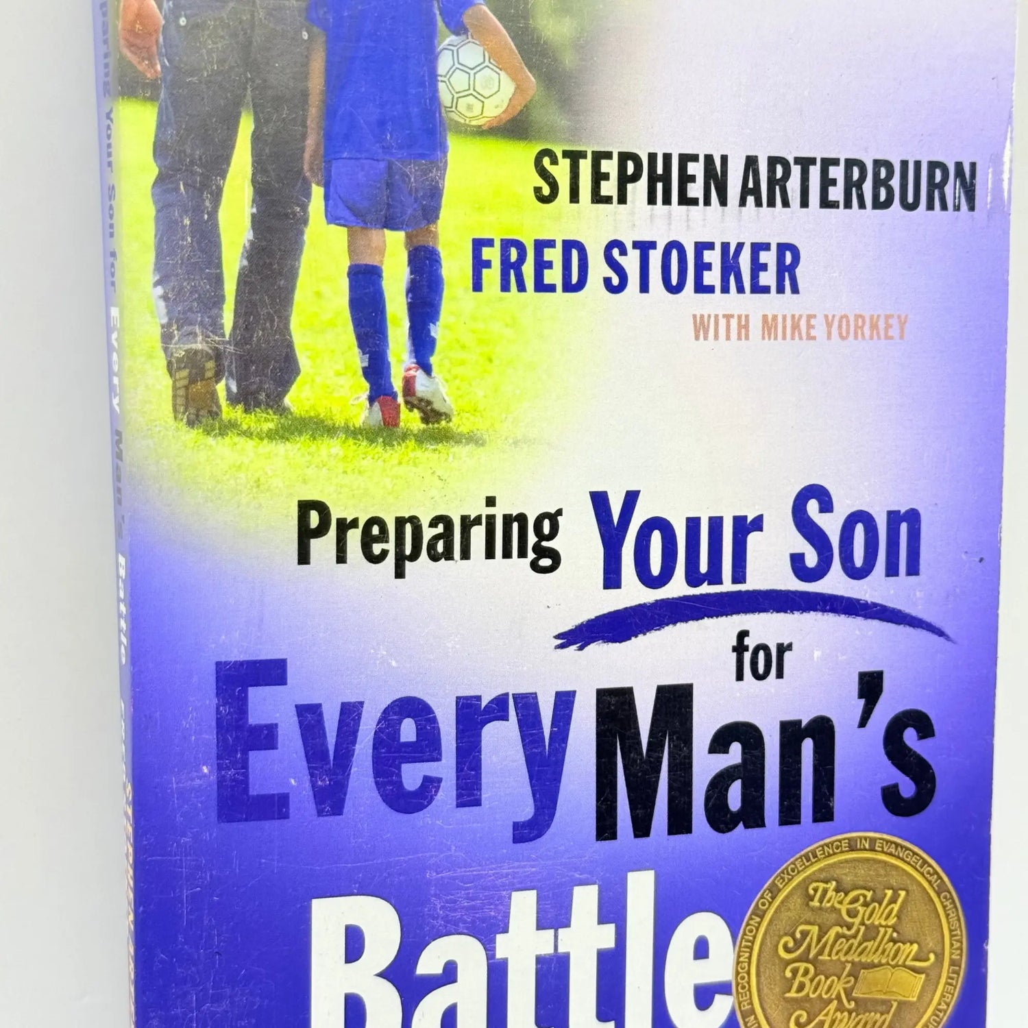 A book titled ’Preparing Your Son for Every Man’s Battle’ with a father and son on the cover.