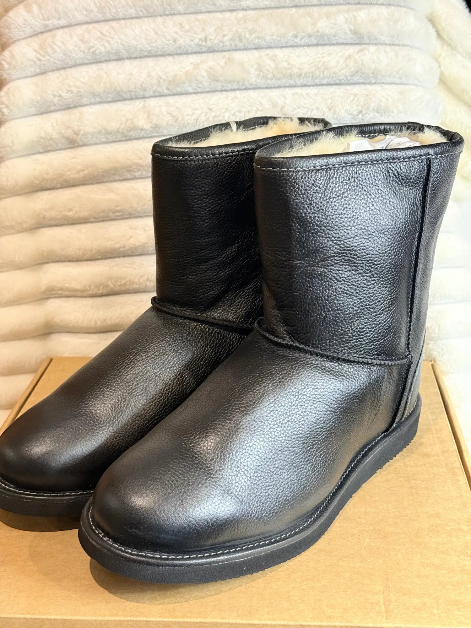 Pair of black leather Ugg boots with a fur lining.