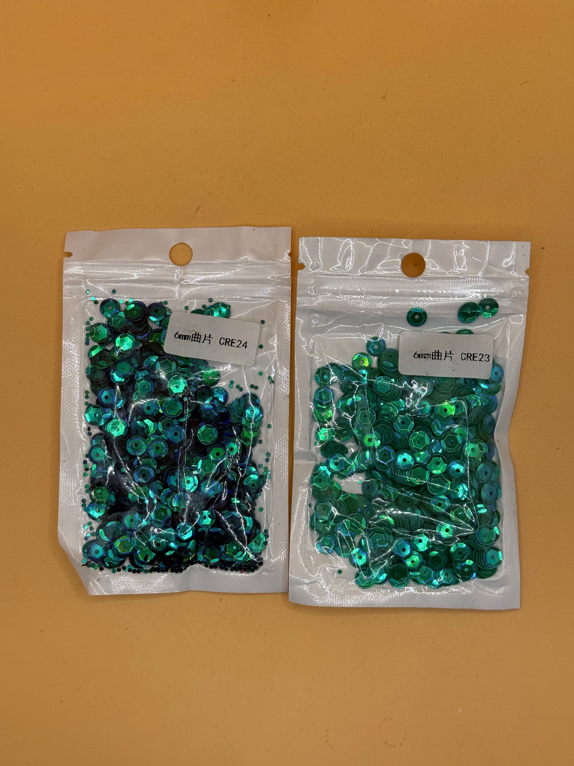 Two packs of 6mm green and iridescent craft sequins