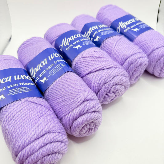 Five skeins of soft purple alpaca wool yarn.