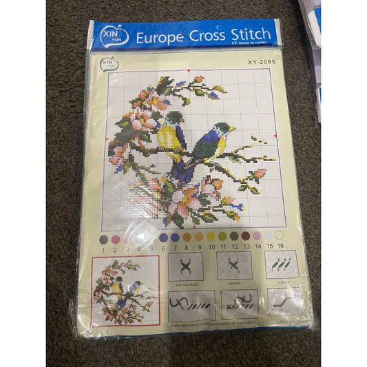 Packaged cross stitch kit with a bird design.