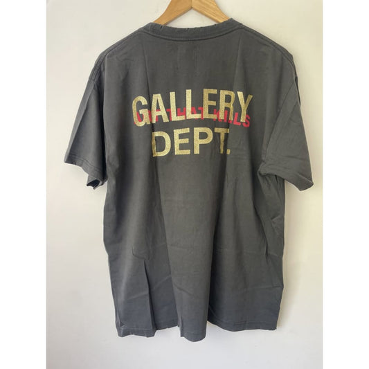 Back of gray Gallery Dept. T-shirt hanging on a wooden hanger.