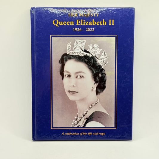 A commemorative book with a blue cover featuring a portrait of Queen Elizabeth II in a tiara and necklace.