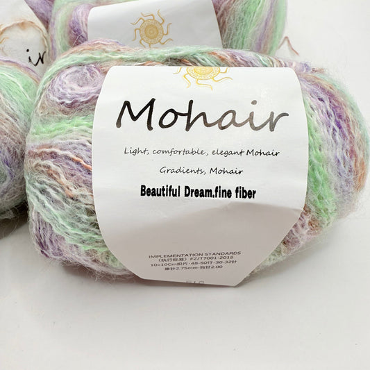 A skein of multi-colored mohair yarn in pastel shades of green, purple, and cream.