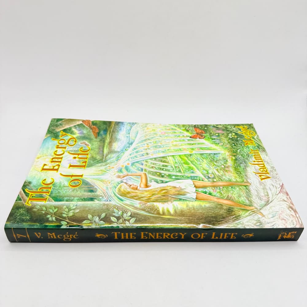 A hardcover book titled ’The Energy of Life’ with a colorful illustration of a woman lying in a forest.